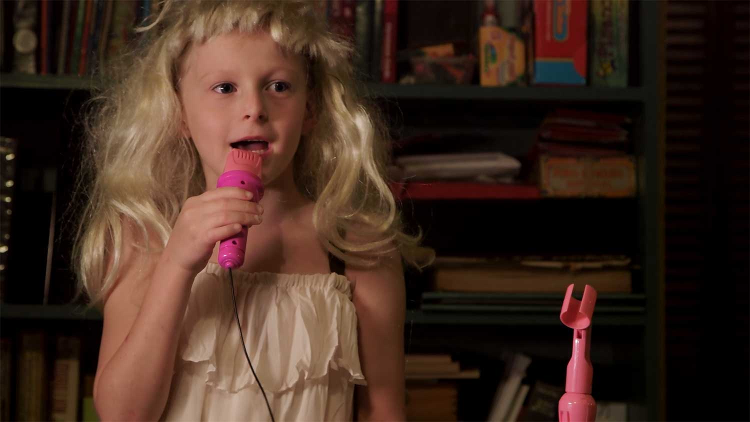 Jeffrey singing into a pink microphone